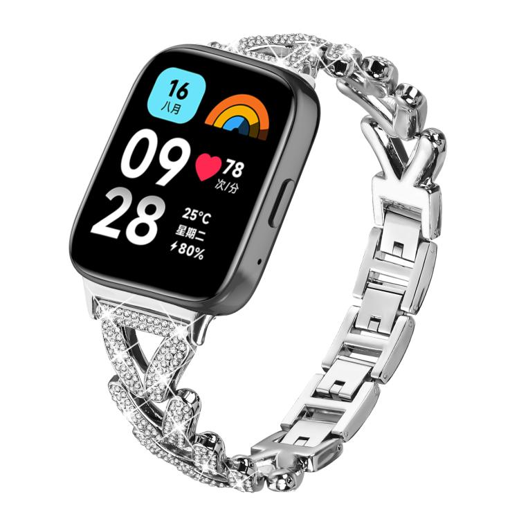 Silver metal smartwatch band with crystal-studded geometric links, shown on a watch