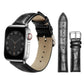 Black textured leather watch band with silver pin buckle, shown attached to a watch.
