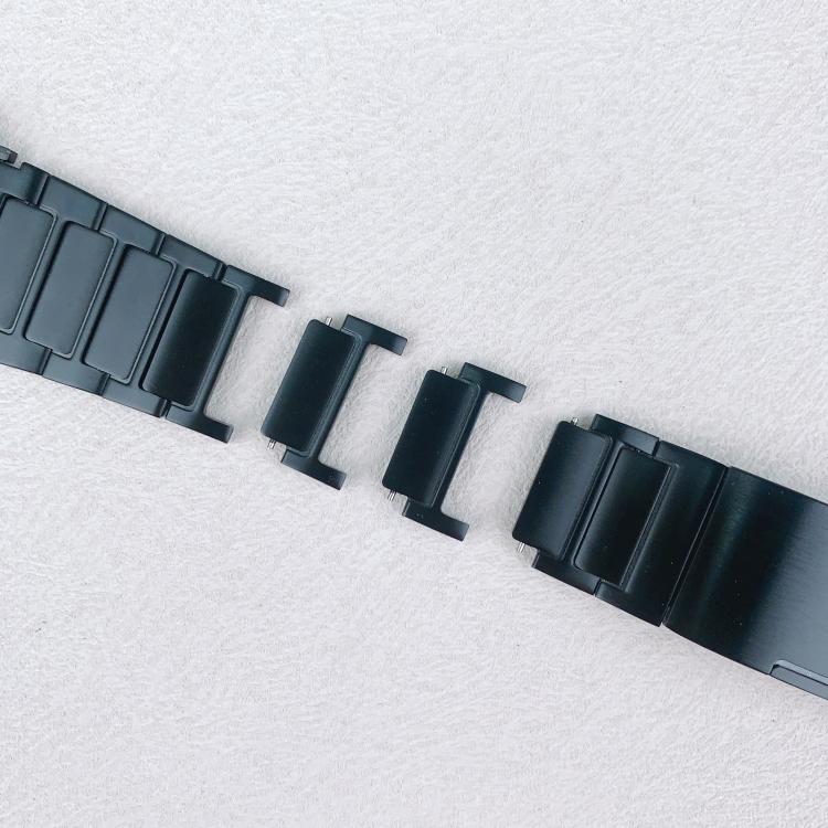 Black watch band with detachable center links laid between the separated band sections.
