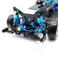 Front-right close-up of RC 4WD chassis with blue shocks, black suspension arms, and tires