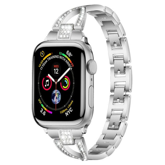 Silver metal Apple Watch band with X-shaped crystal-set links, shown attached to a watch