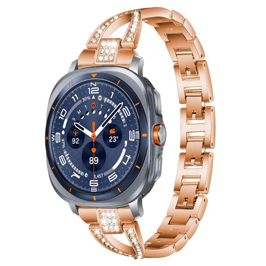 Rose gold X-shaped metal watch band with crystal accents, shown on a smartwatch.