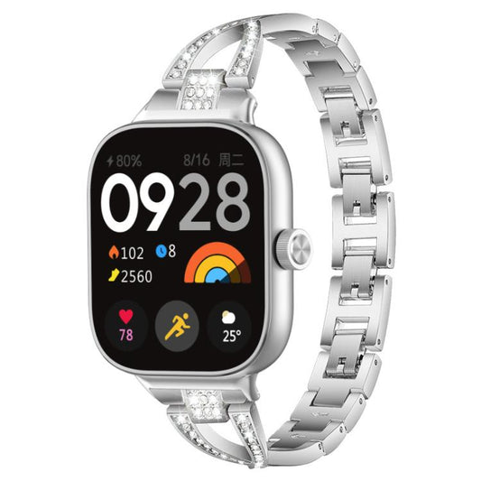 Silver X-shaped metal watch band with crystal accents, shown attached to a smartwatch