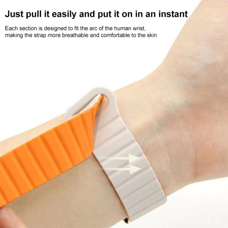 Orange and white silicone watch band shown fastening around a wrist