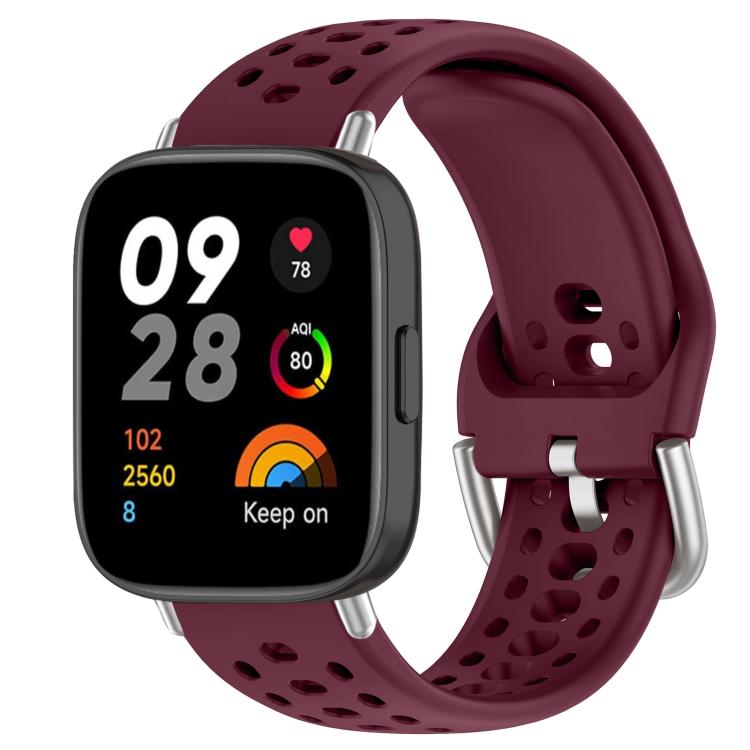 Wine red perforated silicone sport watch band with silver buckle on a black smartwatch
