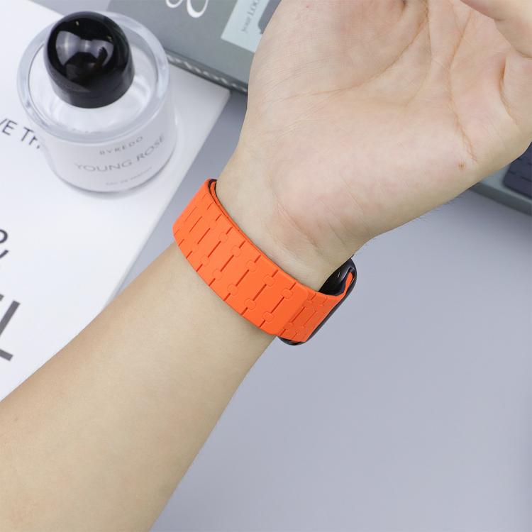 Bright orange silicone watch band worn on a wrist