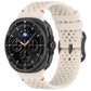 Cream silicone watch band with ventilation holes and black buckle, shown on a smartwatch.