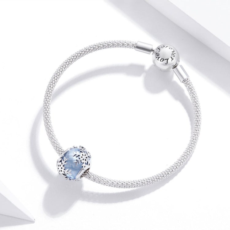 Silver bangle-style bracelet with blue snowflake charm bead and small barrel clasp