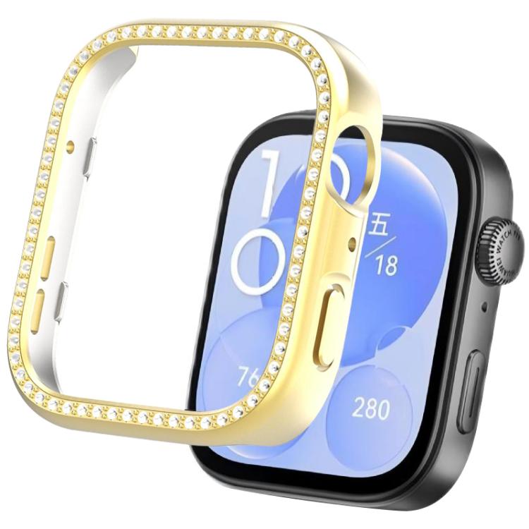 Gold smartwatch protective cover with crystal trim beside a watch