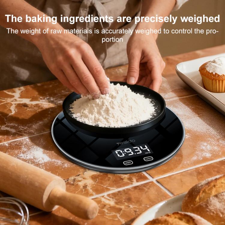 Black smart kitchen electronic scale holding a bowl of flour on top surface