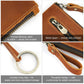 Close-up tan leather clutch showing zipper, stitching, and wrist strap key ring