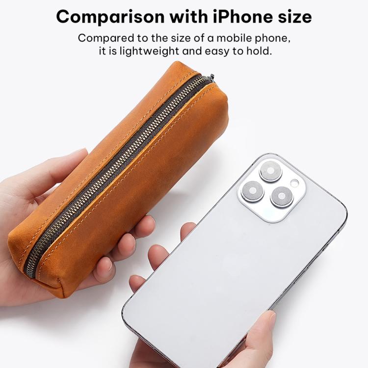 Brown leather zippered pencil case held in hand with slim silhouette