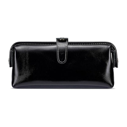 Black leather toiletry bag with top zipper, loop handle, and side tassel pulls