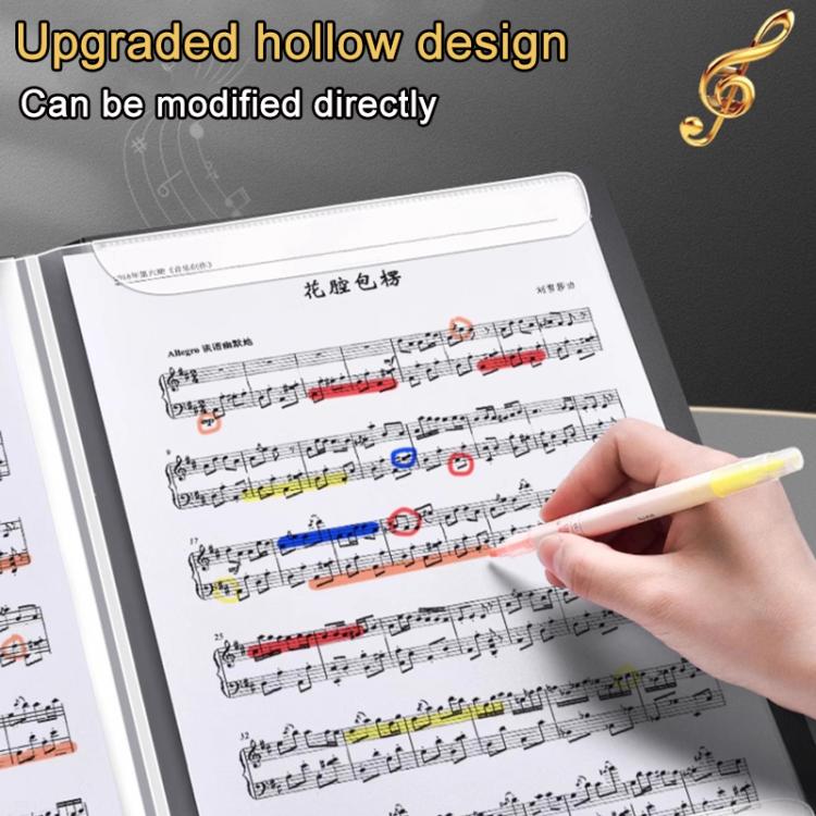 Music score binder open with printed piano sheet music and a hand holding a pen to write