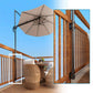 Metal umbrella holder mounted on patio railing posts with black bracket hardware