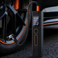 Black dual-screen electric car air pump with orange-tipped hose connected