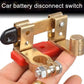 Brass negative battery disconnect switch held in hand, black insulated knob, red base