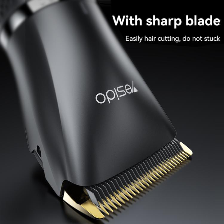 Black trimmer blade head with gold teeth, angled close-up on cordless clipper.
