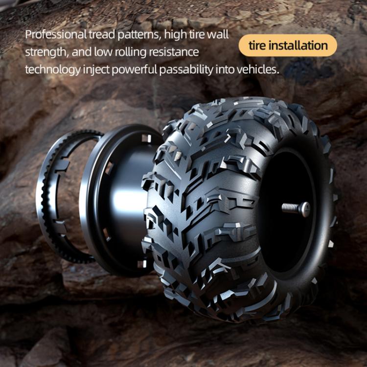 Close-up of 1:14 off-road remote control car wheel with treaded tire on rocky surface.