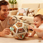Busy board cube toy held by a baby and parent, showing multi-sided activities