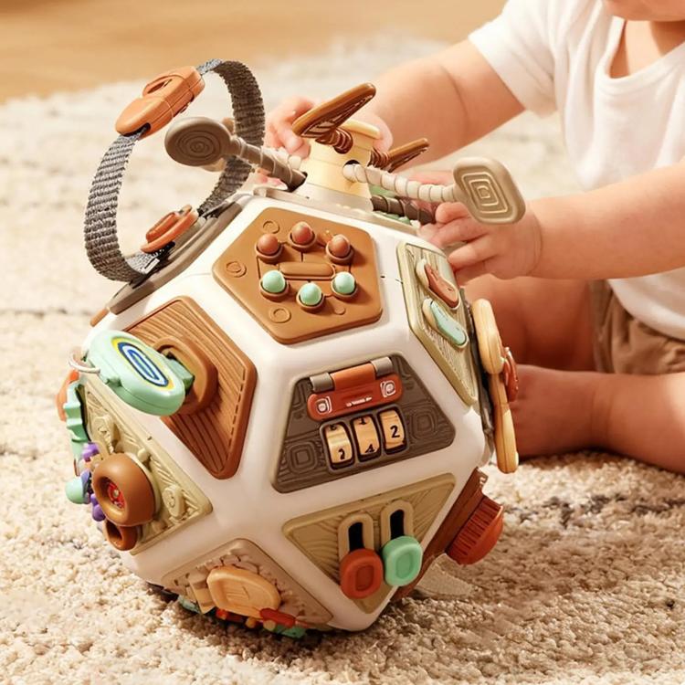 Busy board cube toy with attached cords, switches, and colorful play panels