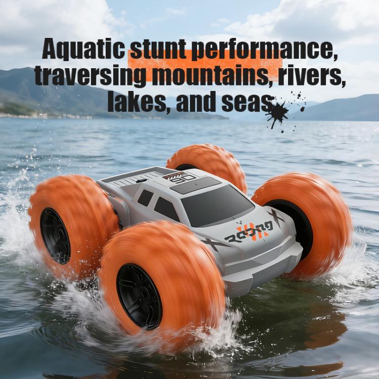 White RC amphibious stunt car with orange tires moving through choppy water.