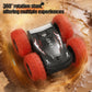 Black RC stunt car with orange wheels spinning 360 degrees in sandy terrain.