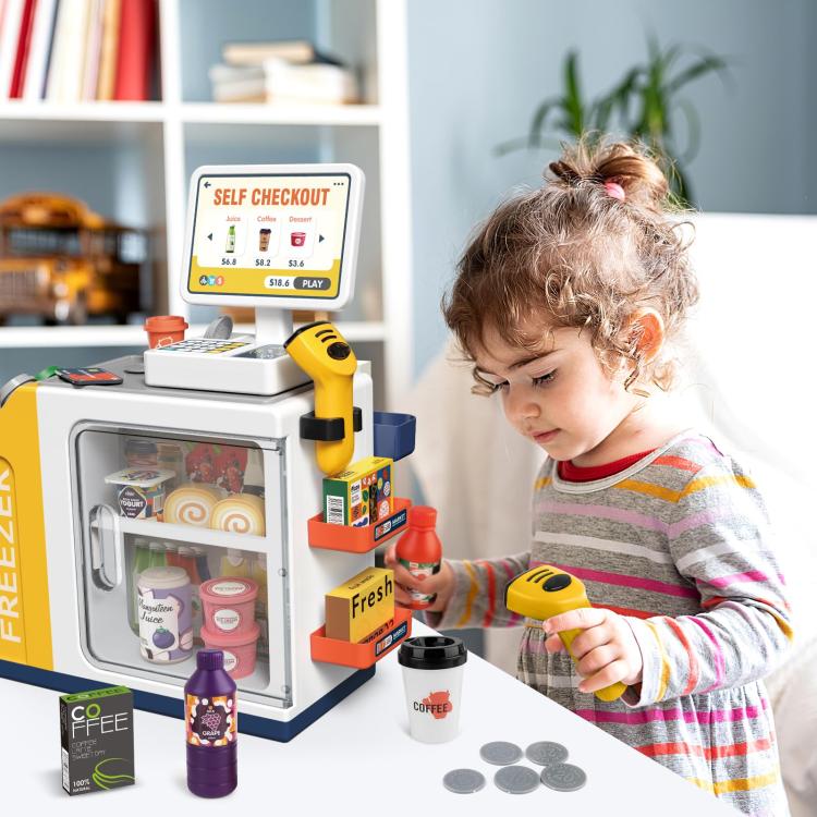 Child playing with yellow self-checkout cash register toy and pretend money coins