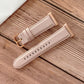 Light pink leather-look watchband with metal buckle and perforated stitching