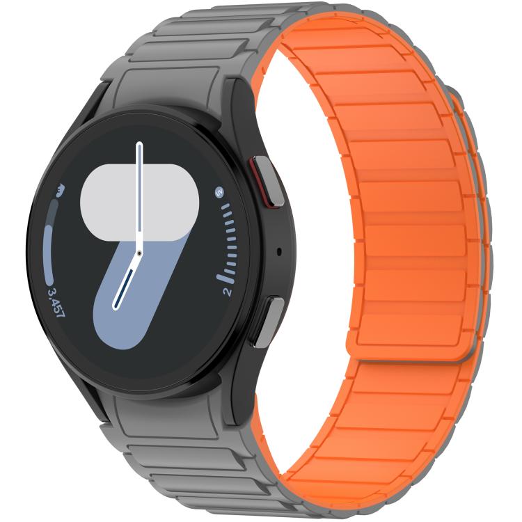 Gray silicone watch band with bright orange inner panels, fitted to a round smartwatch
