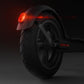 Installed rear fender with glowing red tail light on an electric scooter
