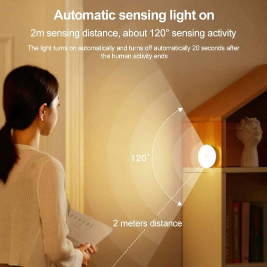 Round LED night light on wall emitting warm light, small circular design