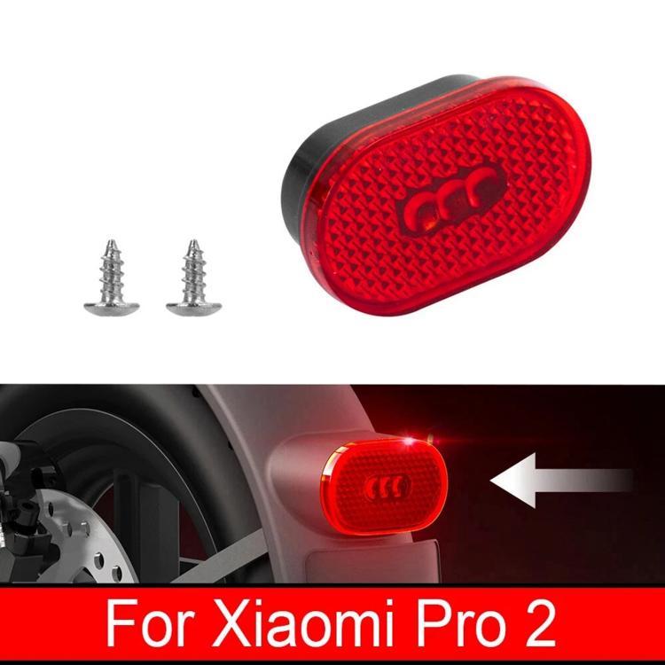 Red oval taillight lens in black housing, close-up with mounting screws