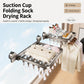Wall-mounted suction cup folding drying rack with clothespins holding socks and underwear