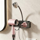 Grey suction-cup wall hair dryer holder with pink dryer, black cradle and cable loop