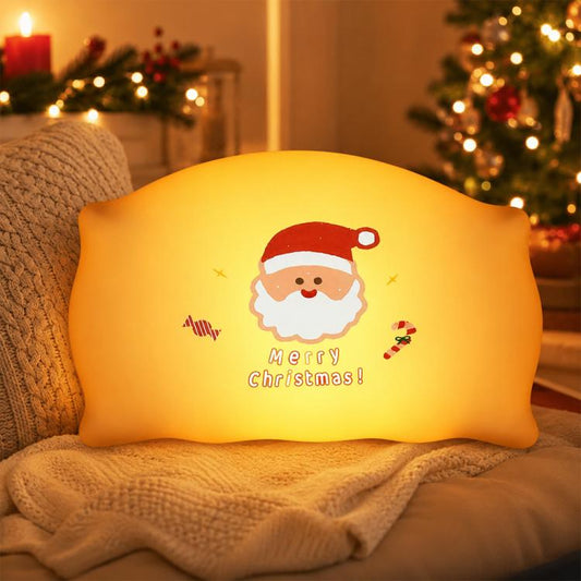 Yellow silicone Christmas night light pillow with Santa Claus graphic and “Merry Christmas”