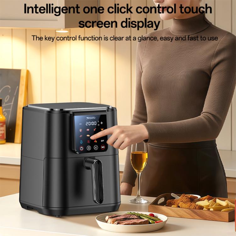 Black 6L air fryer with touch screen control being tapped by a hand