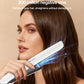 Hair straightener applying to brown hair with glowing mist effect near plates