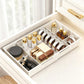 White retractable drawer organizer with dividers holding cosmetics, bottles, and small tubes