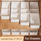 Set of white fold-out drawer bins for organizing small items on a wooden dresser