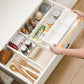 White drawer organizer with removable divider sections for jars, bottles, and utensils