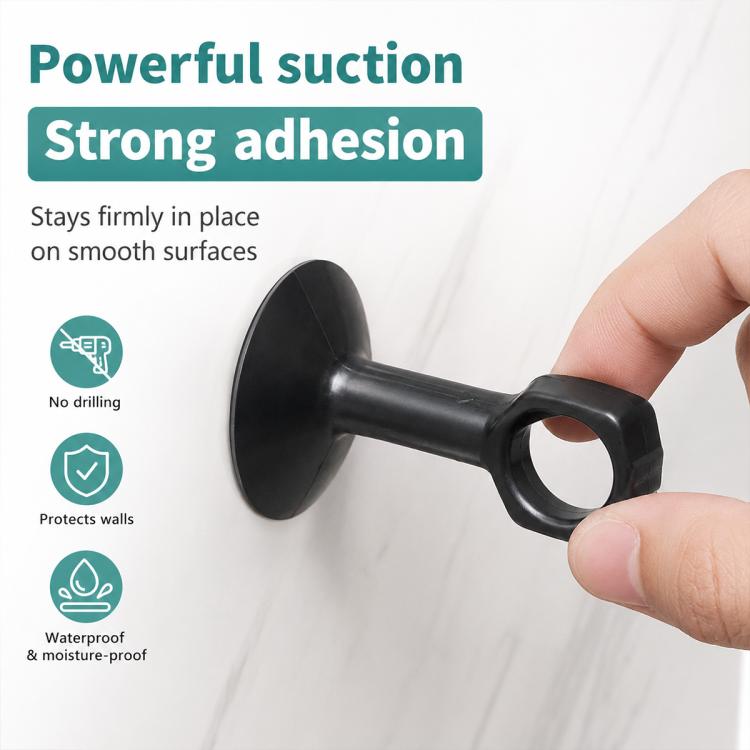 Black suction cup door handle bumper pad attached to a smooth wall surface