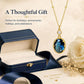 Gold-tone pendant necklace with oval blue stone drop and small round clear centerpiece