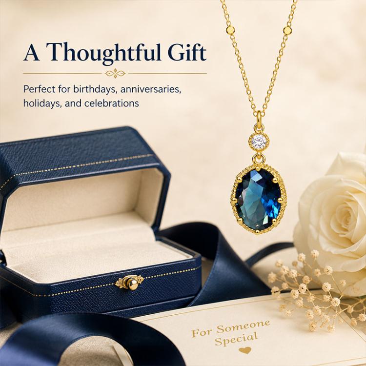 Gold-tone pendant necklace with oval blue stone drop and small round clear centerpiece