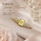 Gold-tone ring with square yellow center stone and round clear stones on slim band.