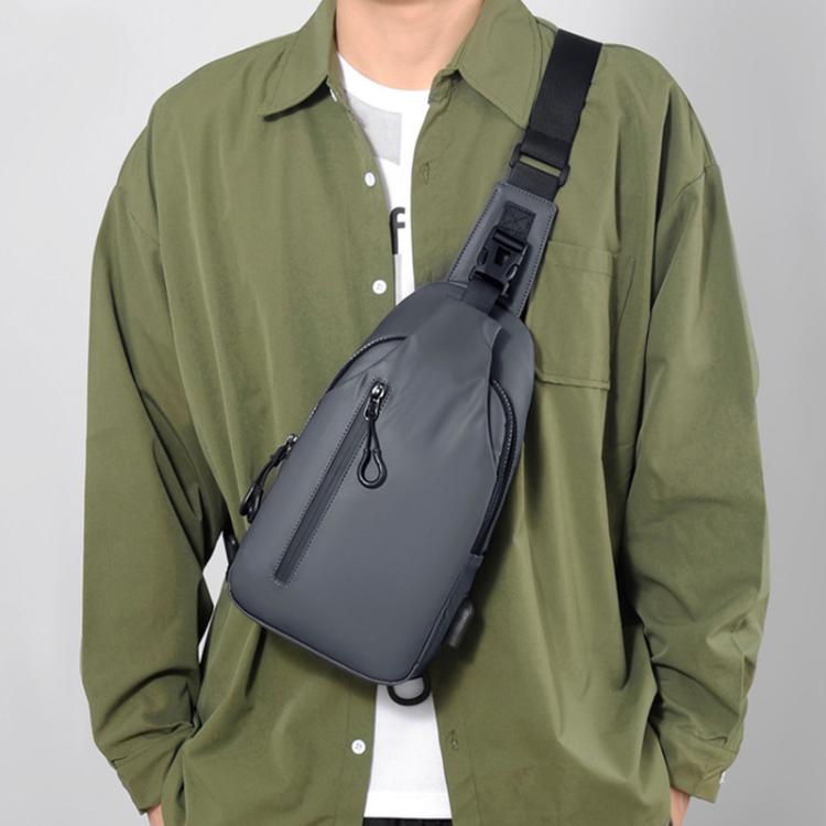 Dark gray crossbody chest sling bag worn on shoulder with adjustable strap.