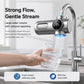 Smart water purifier faucet dispensing a steady stream, with filter cartridge attached