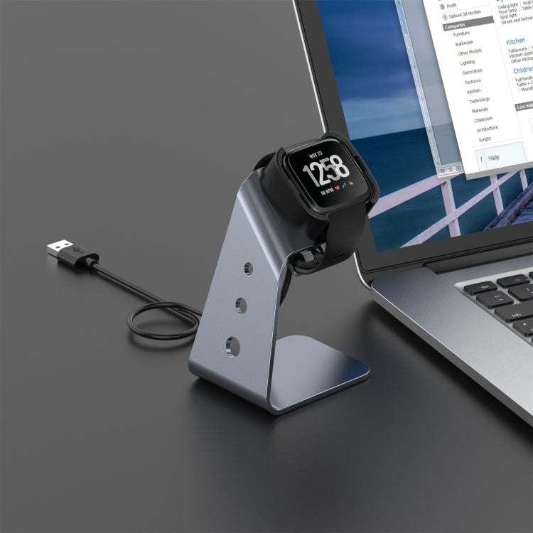 Smartwatch charging on aluminum holder stand with black dock and USB cable