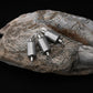 Set of five dual-loop embossed lead sinkers, silver-gray textured cylinders with ring attachments