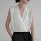 White sleeveless satin blouse featuring a V-neck and tailored center seam